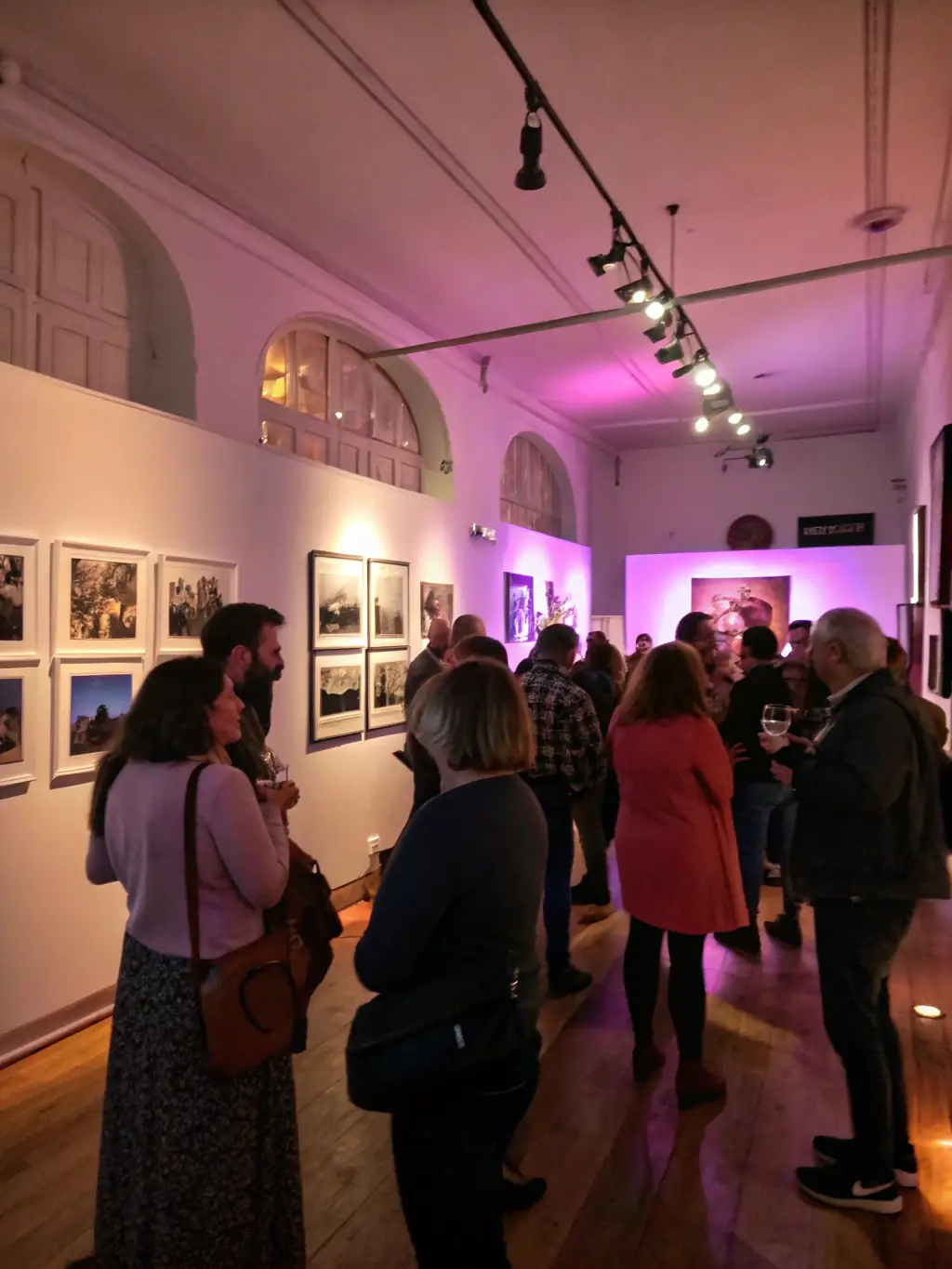 A dynamic image of an art exhibition opening night at FRAC, featuring diverse attendees engaging with the artwork and the artists, highlighting community involvement.